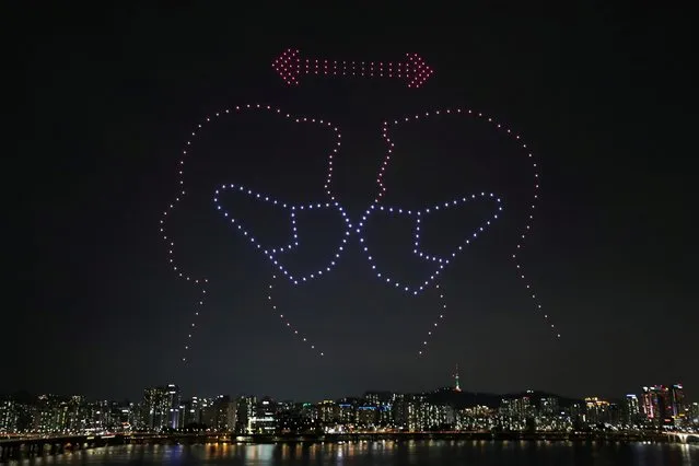 This handout photo taken on July 4, 2020 and released on July 6 by South Korea's Ministry of Land, Infrastructure, and Transport shows a drone display showing messages of support for the country amid the covid-19 pandemic, above the Han river in central Seoul. (Photo by Yonhap via Reuters)