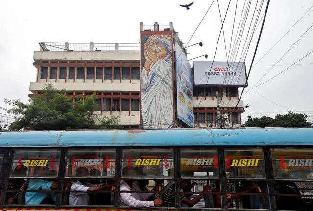 A passenger bus moves past an image of Mother Teresa installed alongside a road ahead of her canonisation ceremony, in Kolkata, India, September 2, 2016. (Photo by Rupak De Chowdhuri/Reuters)