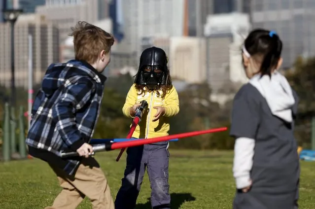 A child wearing a Darth Vader mask participates in a light saber duel with other children after the live internet unveiling of new light saber toys from the film “Star Wars – The Force Awakens” in Sydney, September 3, 2015. (Photo by Jason Reed/Reuters)