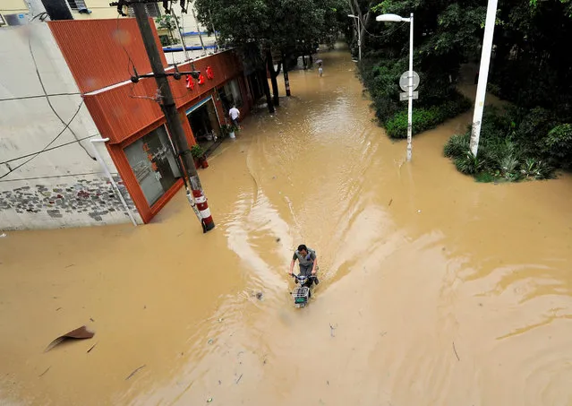 A man rides through a flooded street after Typhoon Meranti made landfall on southeastern China, in Fuzhou, Fujian province, China, September 15, 2016. (Photo by Reuters/Stringer)