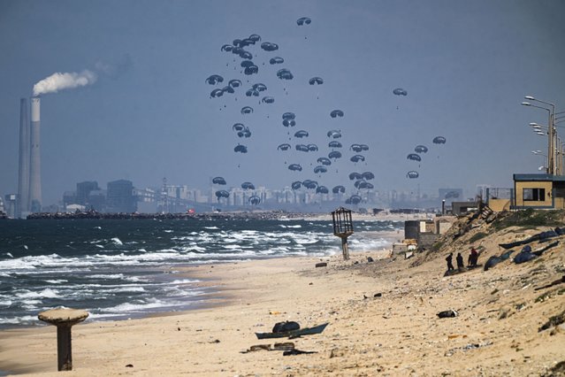 An aircraft airdrops humanitarian aid over the northern Gaza Strip, as seen from central Gaza, Monday, March 25, 2024. (Photo by Fatima Shbair/AP Photo)