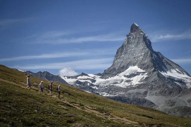 Hikers walk in front with the Matterhorn mountain in background above the resort of Zermatt as heatwave sweeps across Europe on August 8, 2020. (Photo by Fabrice Coffrini/AFP Photo)