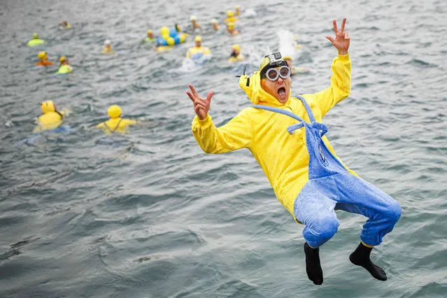 A participant of the 84th edition of the annual Christmas swimming "Coupe de Noel" jumps into Lake Geneva (lac Leman), in Geneva, Switzerland, Saturday, December 17, 2022. (Photo by Valentin Flauraud/Keystone via AP Photo)