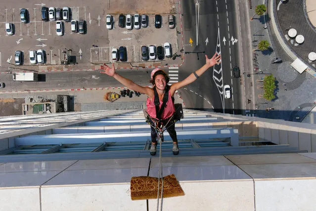 Noa Toledo, 22-year-old window washer and rising social-media star in Israel, poses for a picture while rappelling to clean the facade of a high-rise building in Tel Aviv, Israel on August 5, 2020. (Photo by Nir Elias/Reuters)