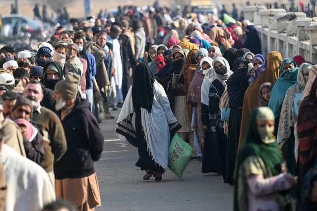 Local residents queue to buy wheat flour at government-controlled prices in Islamabad on January 10, 2023. Pakistan's economy has crumbled alongside a simmering political crisis, with the rupee plummeting and inflation at decades-high levels, but devastating floods and a global energy crisis have piled on further pressure. (Photo by Aamir Qureshi/AFP Photo)