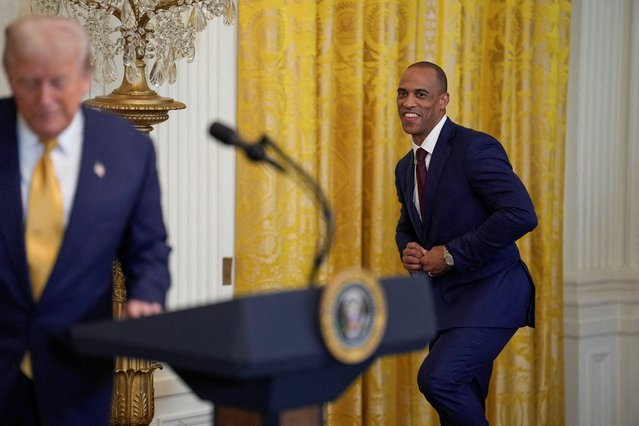 U.S. President Donald Trump stands on stage, as U.S. Secretary of Housing and Urban Development Scott Turner approaches, while Trump hosts a dinner with Republican members of the U.S. Congress in the East Room of the White House on July 22, 2025. (Photo by Kent Nishimura/Reuters)