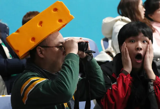 A US fan wearing a cheese hat as another fan reacts as they watch the Men's Curling Round Robin session between Canada and the US at the Gangneung Curling Centre, in Gangneung, during the PyeongChang Winter Olympic Games 2018, South Korea, 19 February 2018. (Photo by Javier Etxezarreta/EPA/EFE)