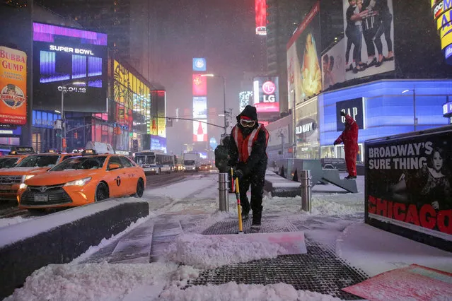 Workers remove snow during a snowstorm in Times Square in Manhattan on January 4, 2018. (Photo by Jeenah Moon/Reuters)