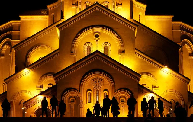 People walk in front of the Holy Trinity cathedral a midnight Christmas service in Tbilisi, Georgia January 7, 2018. (Photo by David Mdzinarishvili/Reuters)