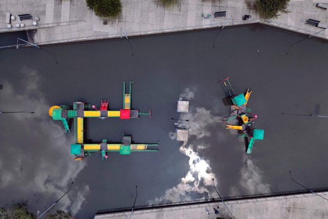 This aerial view shows a flooded park due to heavy rains in the Aztecas neighborhood near the International Mexican Airport “Benito Juarez” in Mexico City on August 12, 2025. Heavy rains battering Mexico City caused chaos again on Tuesday at the capital's airport, where thousands of passengers were stranded due to the temporary suspension of operations. (Photo by Alfredo Estrella/AFP Photo)