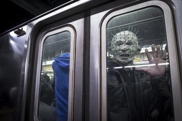 A man dressed up as Pinhead from the Hellraiser series poses for a photo as his subway train pulls away at Times Square station in the Manhattan borough of New York, October 31, 2015. (Photo by Carlo Allegri/Reuters)