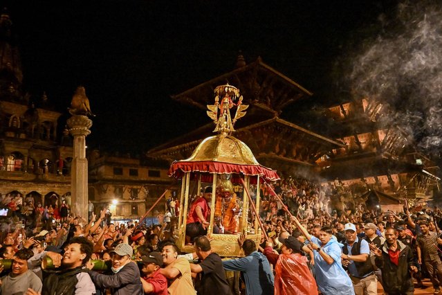 Devotees carry a chariot with the Hindu god Bhimshen at Durbar Square during the “Bhimshen Jatra” festival in Lalitpur on August 17, 2025. (Photo by Prakash Mathema/AFP Photo)