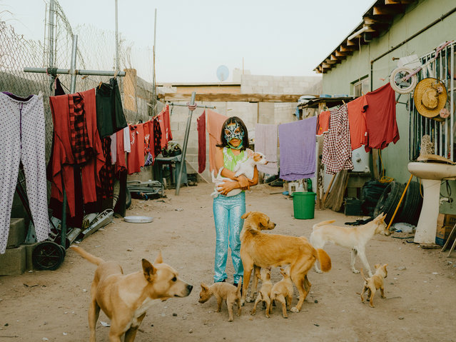 Cross Innovation Day, 2024. Atziry, 9, stands in her courtyard in Ciudad Juárez, Mexico, holding one of seven dogs that provide security in a dangerous environment. In Juárez, where women face persistent threats, even home isn’t always safe. As the daughter of Baby Star, a former Juárez champion, Atziry is part of a family with a long wrestling tradition. Already accompanying her mother to the ring in costume, she may one day step into the ring, continuing her mother’s legacy. (Photo by Jana Margarete Schuler/Siena awards festival 2025)