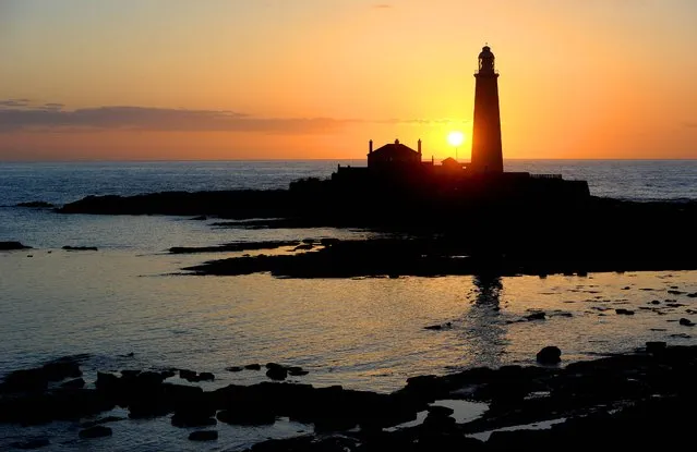 The sun rises over St Mary's Lighthouse at Whitley Bay, North Tyneside, May 2, 2013. (Photo by Owen Humphreys/PA Wire)