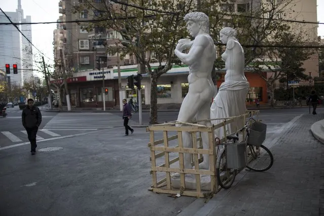 Replica sculptures of “David” and “Venus de Milo” are seen on a street, as they are being transported to a furniture shop as decoration pieces, in Shanghai December 22, 2014. (Photo by Aly Song/Reuters)