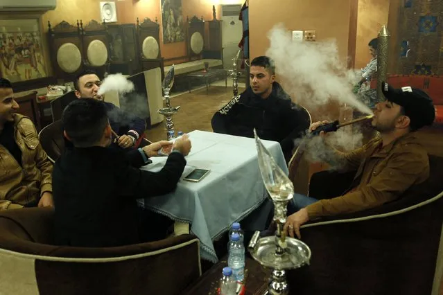 Men smoke shisha at a cafe in Baghdad December 17, 2014. (Photo by Thaier Al-Sudani/Reuters)
