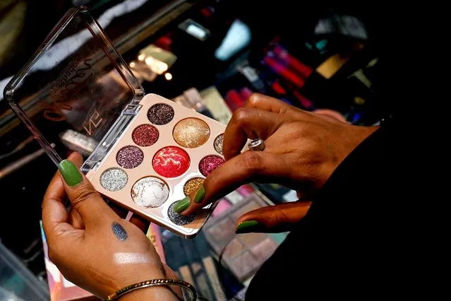 In this picture taken on March 11, 2023, social media make-up influencer Kavita Jadon, 34, checks make-up products in a shop at a fashion outlet market in Bulandshahr, Uttar Pradesh. Cheap internet data, rising income levels and the world's largest population of young people have fuelled an explosion in India's beauty and personal care market, with social media influencers finding fans across the world with a simple mantra: brown is beautiful. (Photo by Arun Sankar/AFP Photo)