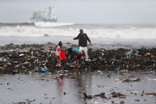 People collect recyclable materials after heavy storms washed large amounts of garbage onto a beach in Acajutla, El Salvador, on June 19, 2024. (Photo by Jose Cabezas/Reuters)
