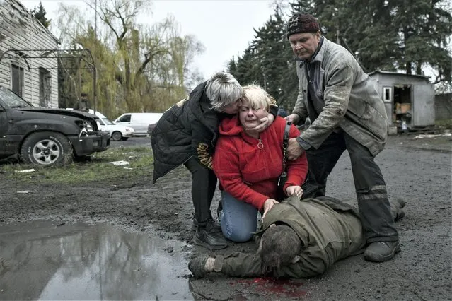 Relatives of one of the people, killed in a strike by Armed Forces of Ukraine at a car base, mourn over his body, in Russian-controlled territory of Donetsk on April 6, 2023. Strike killed at least four people according to reports. (Photo by Stringer/Anadolu Agency via Getty Images)