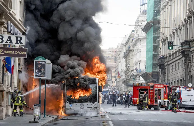Firefighters spray water as they try to extinguish a fire on a public transportation bus in central Rome, Tuesday,  May 8, 2018. Police said the fire, that left one woman slightly burned, was accidental and could have been caused by a short circuit. (Photo by Claudio Peri/ANSA via AP Photo)