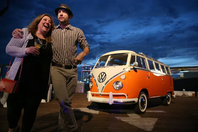 Guests pose in front of an old Volkswagen camper van at an event to unveil the new 2018 Volkswagen Atlas SUV in Santa Monica, California, U.S., October 27, 2016. (Photo by Lucy Nicholson/Reuters)