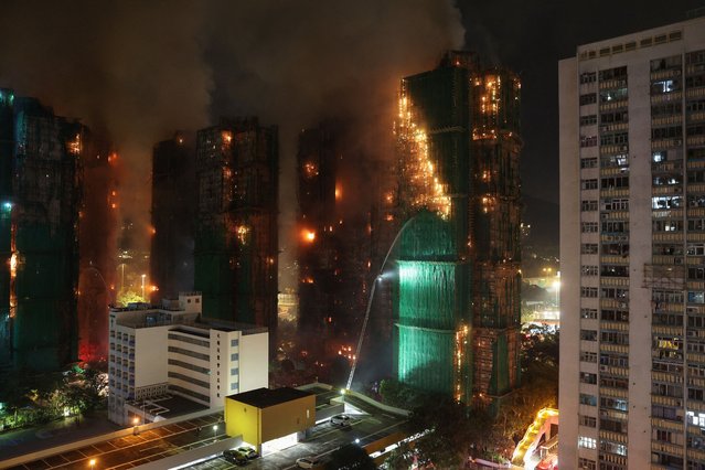Firefighters work to extinguish flames as bamboo scaffolding burns across multiple buildings at Wang Fuk Court housing estate in Tai Po, Hong Kong, China, on November 26, 2025. (Photo by Tyrone Siu/Reuters)