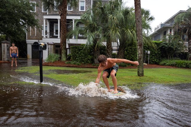 A youth slides on flood water in a street as Tropical Storm Debby moves off Georgia to the North Atlantic, in Isle of Palms, South Carolina on August 6, 2024. (Photo by Marco Bello/Reuters)
