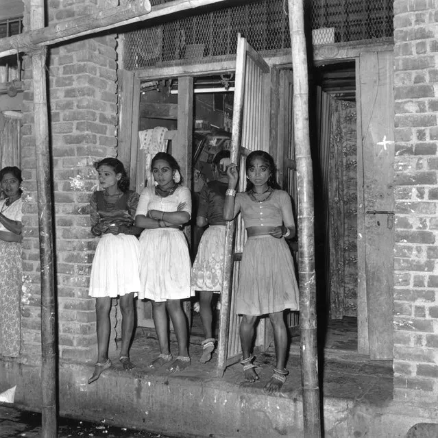 6th December 1964:  Three prostitutes waiting in a doorway in India.  (Photo by Terry Fincher/Express/Getty Images)