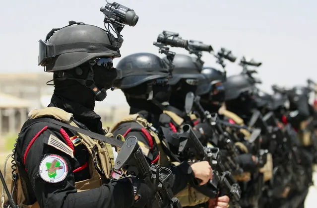 Iraqi anti-terrorism special forces stand at attention before a simulated hijacking of a plane, during a training exercise in Baghdad airport, Iraq, Wednesday, June 19, 2013. Iraqi police performed Wednesday an operational-tactical drill on how to manage a crisis situation caused by a terrorist act in civil aviation. (Photo by Hadi Mizban/AP Photo)