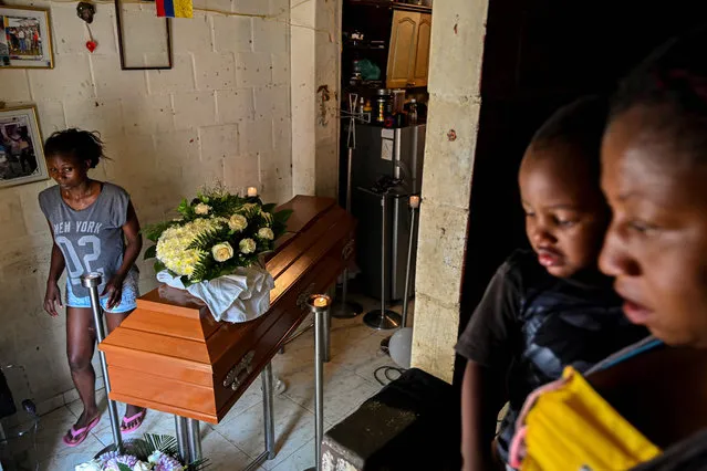 Relatives mourn next to the coffin of one of five youngsters found murdered in a sugar cane field during their funeral in Aguablanca district, in the east of Cali, Colombia, on August 13, 2020. Over 460 murders were registered in Cali from January to June 2020 according to an official report. (Photo by Luis Robayo/AFP Photo)