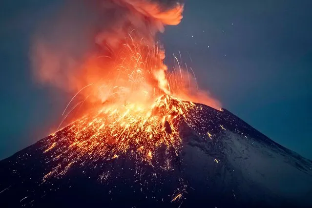 Incandescent materials, ash and smoke are spewed from the Popocatepetl volcano as seen from thr Santiago Xalitzintla community, state of Puebla, Mexico, on May 22, 2023. (Photo by Erik Gomez Tochimani/AFP Photo)