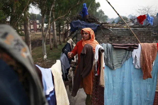 A Christian woman arranges laundry on the roof top of her house in a Christian colony in Islamabad January 20, 2015. (Photo by Sara Farid/Reuters)