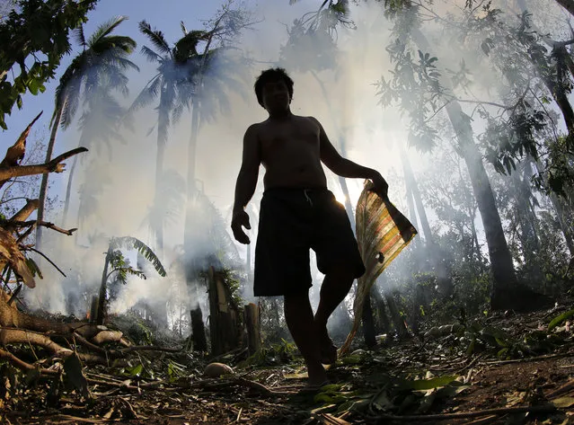 A Filipino villager burns debris in the typhoon-hit town of Donsol, Sorsogon province, southern Manila, Philippines, December 16, 2015. Philippine relief officials rushed aid to tens of thousands of people affected by a typhoon that left at least nine people dead. The National Disaster Risk Reduction and Management Council (NDRRMC) said large swathes of the eastern and central Philippines have been affected by Typhoon Melor. (Photo by Francis R. Malasig/EPA)