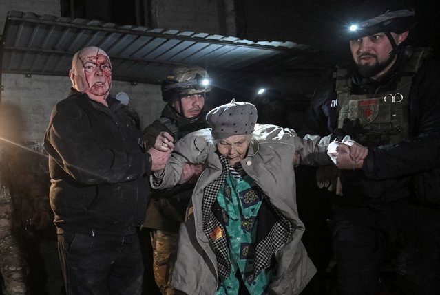Police officers and a wounded resident evacuate an elderly woman from an apartment building hit by a Russian missile strike, amid Russia's attack on Ukraine, in Zaporizhzhia, Ukraine on January 23, 2025. (Photo by Reuters/Stringer)