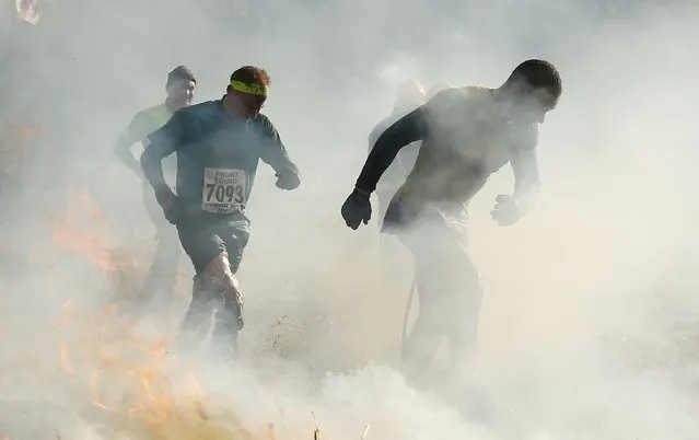 Competitors run through smoke and fire during the Tough Guy event in Perton, central England, February 1, 2015. (Photo by Phil Noble/Reuters)