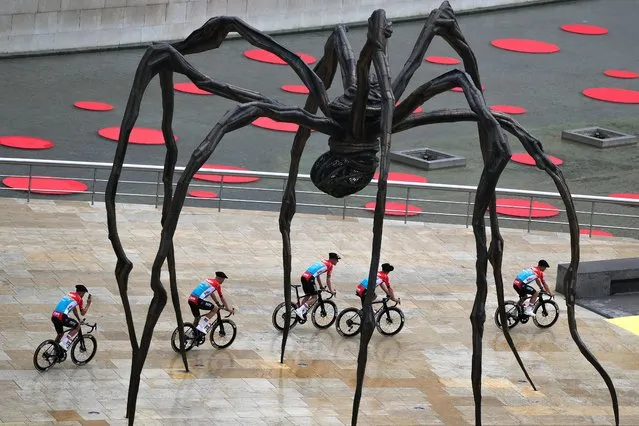 A general view of Victor Campenaerts of Belgium, Jasper De Buyst of Belgium, Pascal Eenkhoorn of The Netherlands, Caleb Ewan of Australia, Frederik Frison of Belgium, Jacopo Guarnieri of Italy, Maxim Van Gils of Belgium, Florian Vermeersch of Belgium and Team Lotto Dstny pass underneath the Mama spider sculpture during the team presentation of the 110th Tour de France 2023 at the Guggenheim Museum Bilbao / #UCIWT / on June 29, 2023 in Bilbao, Spain. (Photo by David Ramos/Getty Images)