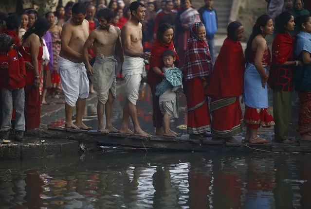 Devotees cross the Hanumante River as they arrive to take part in the final day of the month-long Swasthani festival at Bhaktapur, near Kathmandu February 3, 2015. (Photo by Navesh Chitrakar/Reuters)