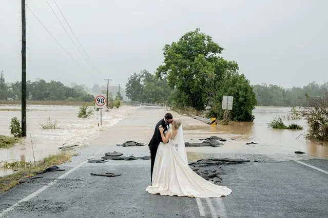 Bride and groom Kate Fotheringham and Wayne Bell kiss in front of a flooded bridge that had blocked their five-minute drive into town, requiring a rescue by helicopter to get them to the church on time, in Port Macquarie, Australia on March 20, 2021. (Photo by Amanda Hibbard, Kate Fotheringham via Reuters)