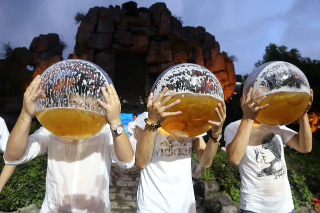 People drink beer from fish bowls at a beer drinking competition in Hangzhou, Zhejiang province, China July 21,2018. (Photo by Reuters/China Stringer Network)