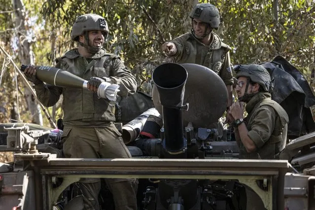 Israeli soldiers load ammunition onto an Armored Personal Carrier (APC) at a staging ground near the Israeli Gaza border, Friday, May 14, 2021. (Photo by Tsafrir Abayov/AP Photo)