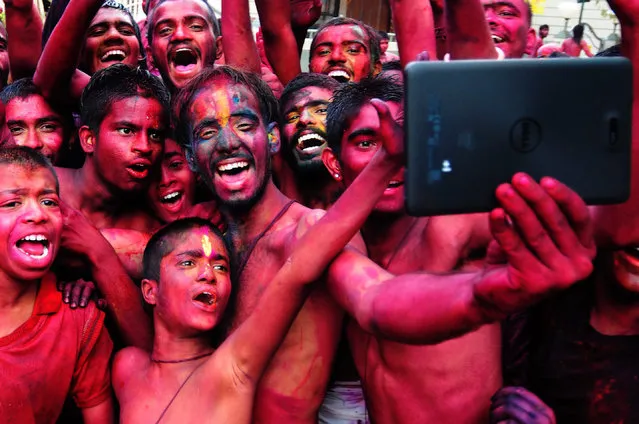 epa04649961 Indian revellers smeared with colors take selfies during the Holi Festival in Bangalore, India, 06 March 2015. Holi is celebrated at the end of the winter season on the last full moon day of the lunar month Phalguna (February or March) and its main day is celebrated by people throwing colored powder and colored water at each other.  EPA/JAGADEESH NV