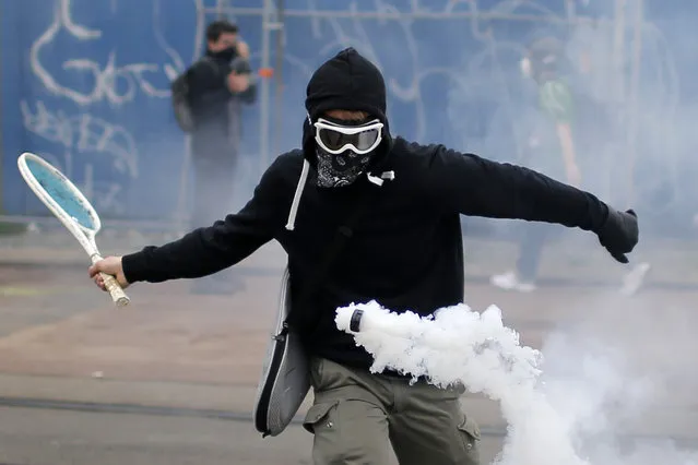 A protester uses a tennis racket to return a tear gas canister during a demonstration to protest the government's proposed labor law reforms in Nantes, France, June 2, 2016. (Photo by Stephane Mahe/Reuters)