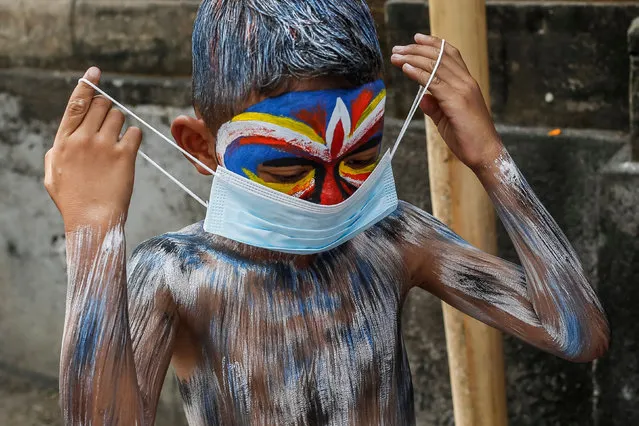 Balinese have their bodies painted and wears protective mask during sacred Ngerebeg ritual amid COVID-19 pandemic at Tegallalang Village in Gianyar, Bali, Indonesia on May 19 2021. Ngerebeg is a sacred ritual held every six month which is believed to expel bad luck and evil spirits. The participants decorates their bodies with colourful paints and accessories to symbolise astral beings while marching across the village. (Photo by Johanes Christo/NurPhoto/Rex Features/Shutterstock)