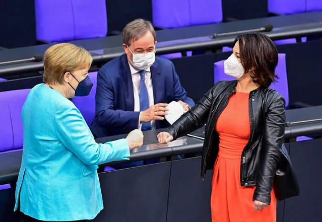 German Chancellor Angela Merkel (L), the candidate for Chancellor of the Christian Democratic Union (CDU) Armin Laschet and the candidate for Chancellor of the Greens (Die Gruenen) party and Annalena Baerbock wear face masks as they greet each other prior a session at the Bundestag (lower house of parliament) ahead of an EU summit, on June 24, 2021 in Berlin. (Photo by Tobias Schwarz/AFP Photo)
