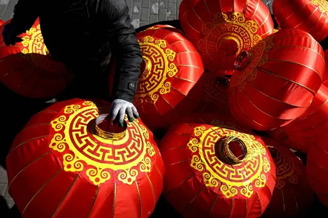 A worker prepares to set up Chinese lanterns to decorate on a street ahead of the Lunar New Year in Beijing, Sunday, January 31, 2016. Chinese will celebrate the Lunar New Year on Feb. 8 this year which marks the Year of Monkey on the Chinese zodiac. (Photo by Andy Wong/AP Photo)