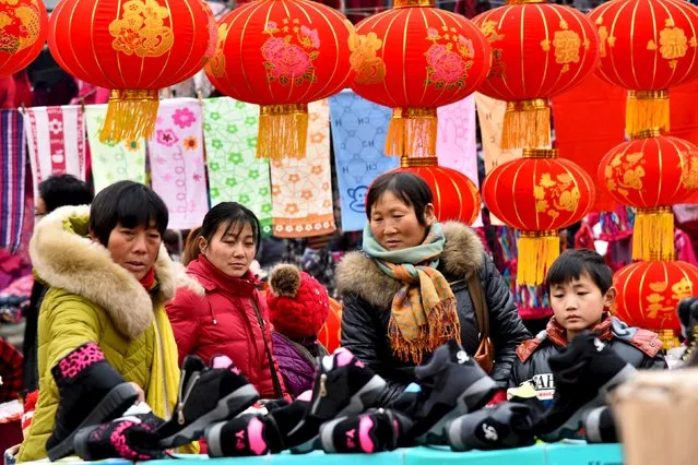 People shop at a new year market ahead of the upcoming Spring Festival in Zaozhuang, Shandong province, January 28, 2016. (Photo by Reuters/China Daily)