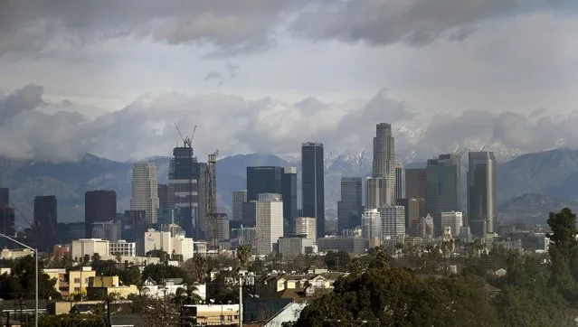 Downtown Los Angeles skyline is seen in front of the snow covered San Gabriel Mountains following a series of El Nino driven storms in Los Angeles, California January 7, 2016. (Photo by Bob Riha Jr./Reuters)