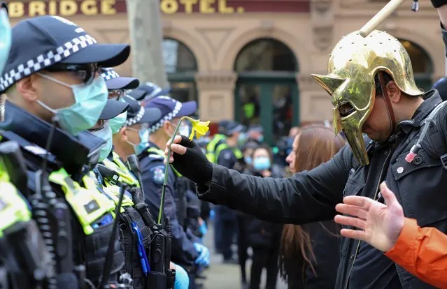 A protester approaches Police officers during “Freedom Rally” on July 24, 2021 in Melbourne, Australia. Anti-lockdown and anti-vaccination activists gathered in cities across Australia with New South Wales and Victoria under strict Covid-19 restrictions as the states continue to fight the spread of the delta coronavirus strain. (Photo by Diego Fedele/Getty Images)