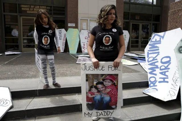 The family of Jose de la Trinidad, 36, who was fatally shot by Los Angeles County sheriff's deputies, stand outside the LA County Board of Supervisors' office where cardboard coffins were leant to commemorate the more than 617 people march organizers say have been killed by law enforcement in LA County since 2000, in Los Angeles, California April 7, 2015. (Photo by Lucy Nicholson/Reuters)