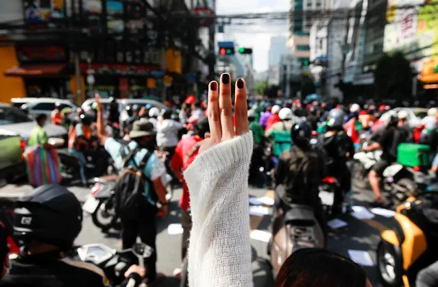 A demonstrator shows the three-finger salute during a protest against the government's handling of the coronavirus disease (COVID-19) pandemic, in Bangkok, Thailand, August 10, 2021. Protesters demanded the resignation of Prime Minister Prayuth Chan-ocha for his failure in handling the COVID-19 pandemic. (Photo by Soe Zeya Tun/Reuters)